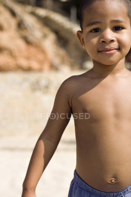 Menino pré-escolar em pé na praia . — Fotografia de Stock