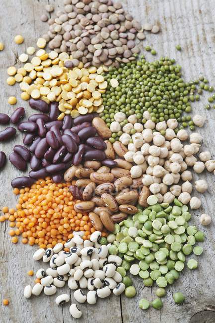 Dried beans, peas and lentils on wooden table. — Stock Photo