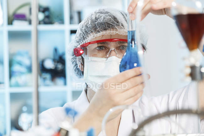 Mujer haciendo experimento en laboratorio químico . - foto de stock