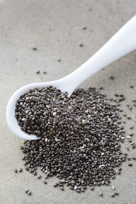 Mucchio di semi di chia in cucchiaio bianco . — Foto stock
