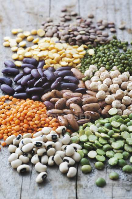 Dried beans, peas and lentils on wooden table — Stock Photo