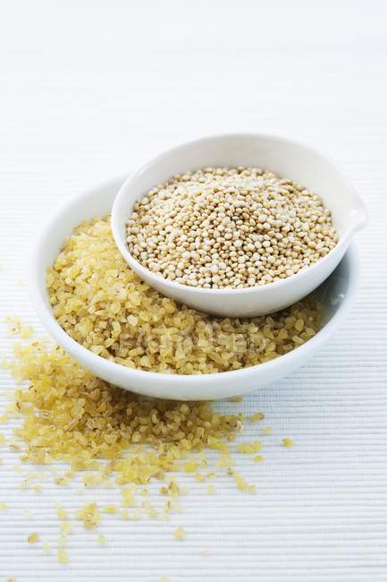 Sementes de quinoa e bulgur em taças . — Fotografia de Stock
