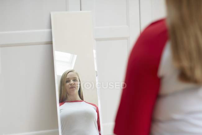 Mulher olhando para a reflexão no espelho — Fotografia de Stock