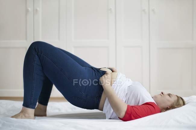 Женщина пытается застегнуть джинсы . — стоковое фото