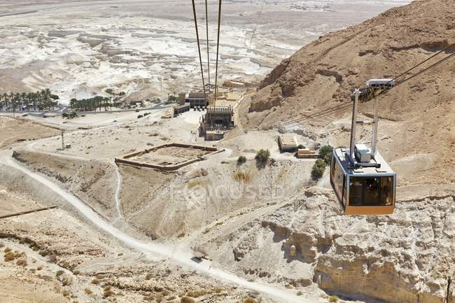 Teleférico ascendiendo con ruinas antiguas en el fondo, Israel, Masada - foto de stock