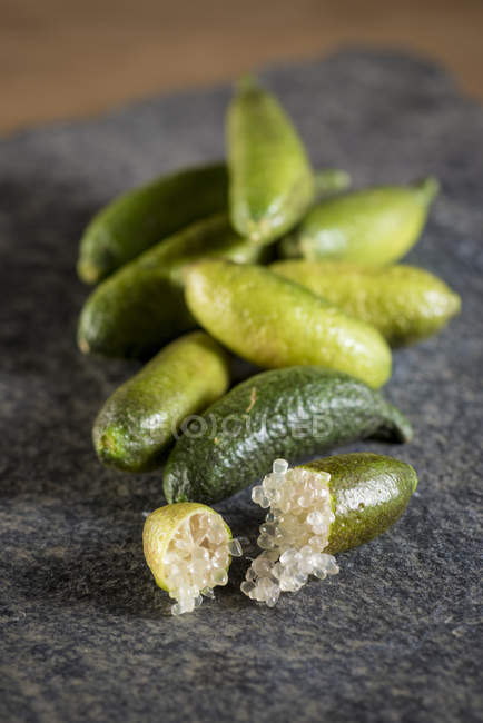 Vue rapprochée du doigt limes fruits, nature morte . — Photo de stock