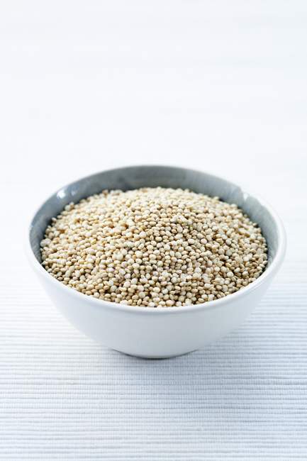 Sementes de quinoa em tigela sobre fundo branco . — Fotografia de Stock