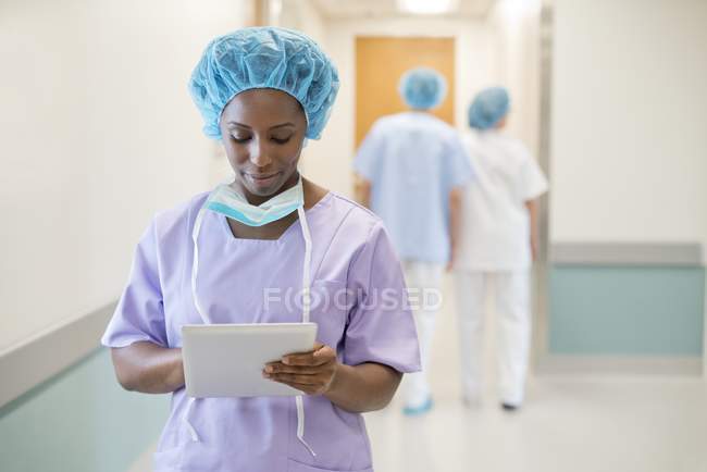 Chirurgo femminile che utilizza tablet digitale in ospedale . — Foto stock