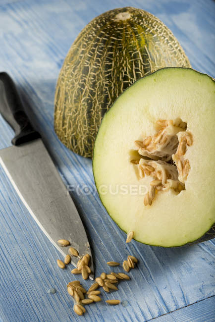 Piel de sapo melon cut in half with seeds. — Stock Photo