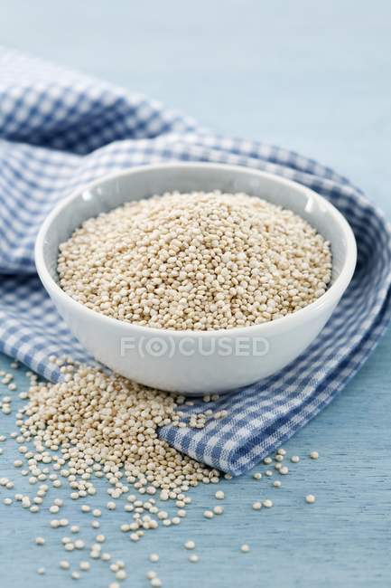 Sementes de quinoa em tigela na toalha de cozinha — Fotografia de Stock