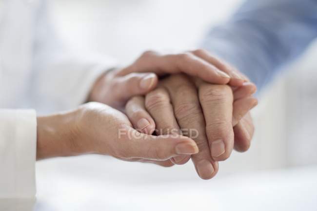 Женщина-врач держит пожилого пациента за руку . — стоковое фото