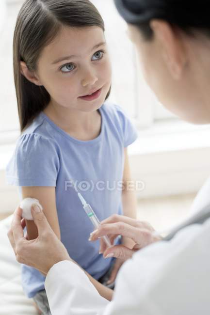 Femme médecin donnant injection de fille préadolescente . — Photo de stock