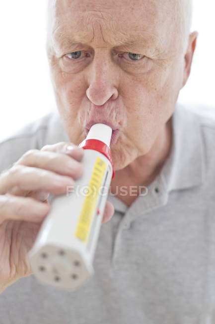 Senior man using peak flow meter, close-up. — Stock Photo
