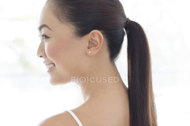 Jeune femme souriante avec queue de cheval, profil . — Photo de stock