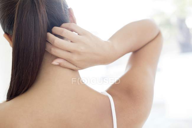 Jeune femme qui gratte le cou, vue arrière . — Photo de stock