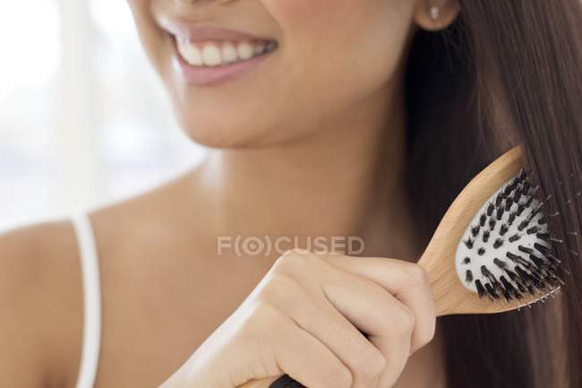 Femme brossant les cheveux — Photo de stock