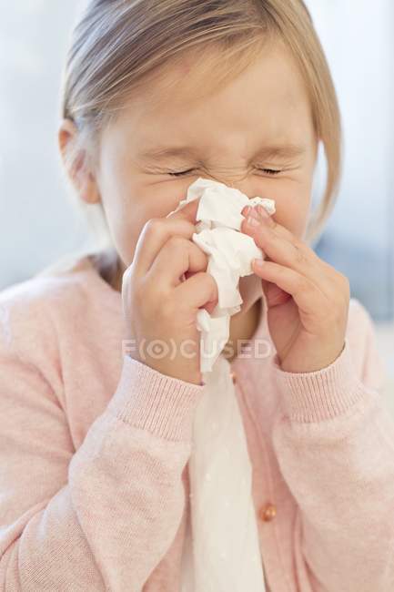 Elementary idade menina espirrando em tecido . — Fotografia de Stock