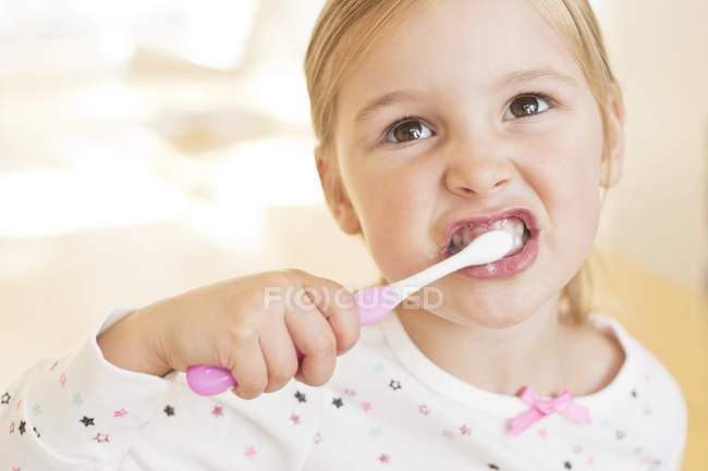Elementary age girl brushing teeth. — Stock Photo