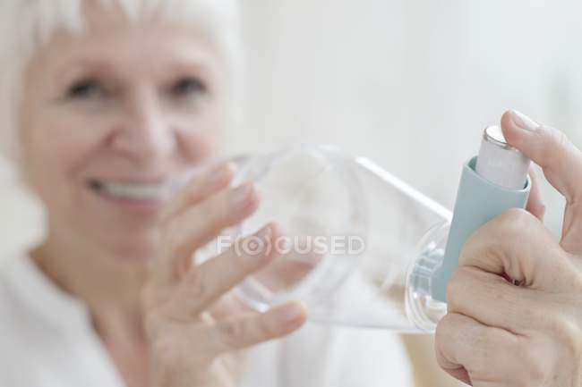 Senior woman holding inhaler, close-up. — Stock Photo