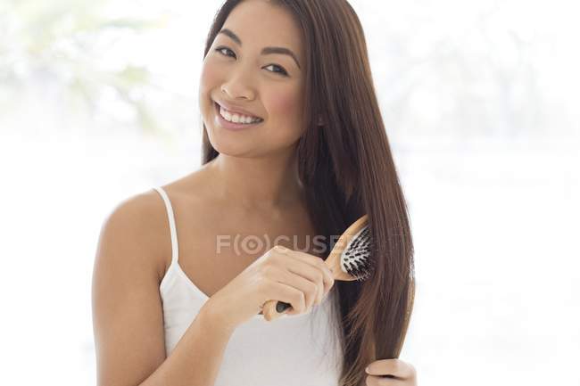 Mujer cepillarse el cabello - foto de stock