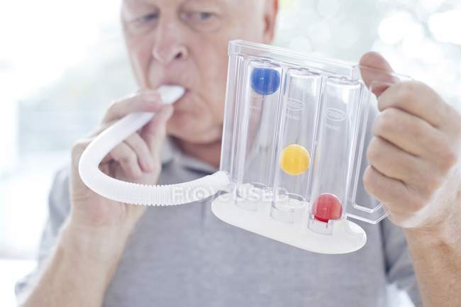 Senior man using incentive speedometer with tube. — Stock Photo