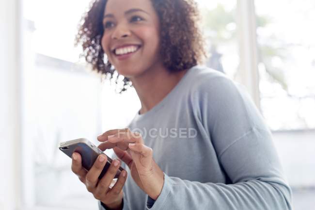 Donna felice utilizzando il telefono cellulare — Foto stock