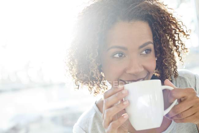 Mulher bebendo café e olhando para longe — Fotografia de Stock