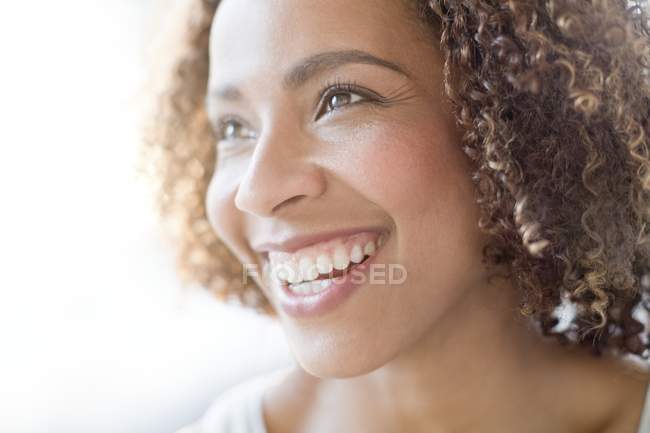 Mujer feliz sonriendo y mirando hacia otro lado - foto de stock