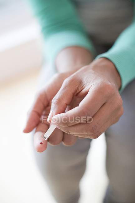 Mujer haciendo la prueba de pinchazo dedo . - foto de stock