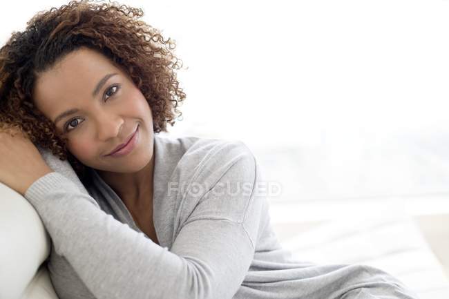 Красивая женщина улыбается сидя в помещении — стоковое фото