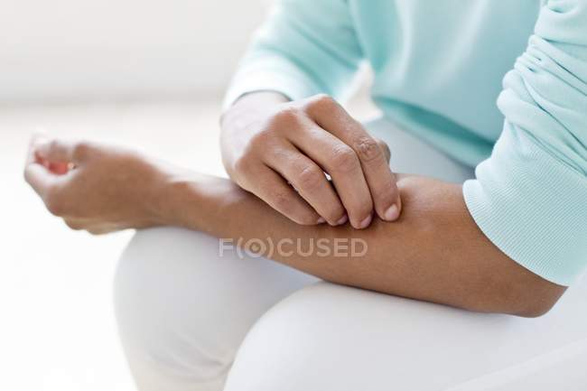 Donna graffiare braccio — Foto stock