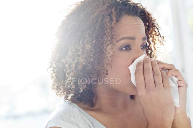 Donna soffiando naso sul tessuto . — Foto stock