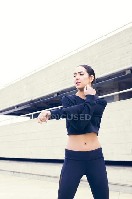 Frau in Sportkleidung streckt die Hände. — Stockfoto