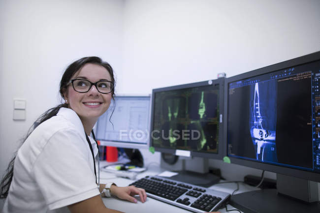 Лікарняний радіолог сидить за столом перед скануванням КТ . — стокове фото