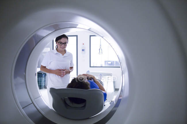 Radiólogo hablando con el paciente en el escáner CT . - foto de stock