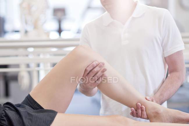 Physiotherapeutin massiert weibliche Beine. — Stockfoto