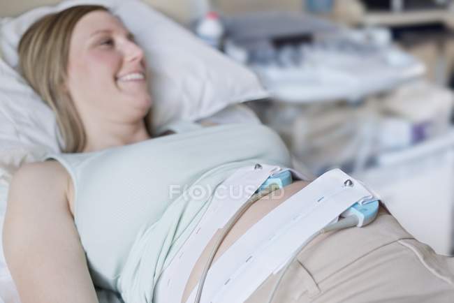 Mulher grávida com monitor de frequência cardíaca na barriga . — Fotografia de Stock