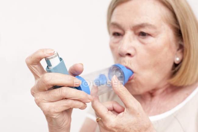 Donna anziana che usa l'inalatore . — Foto stock