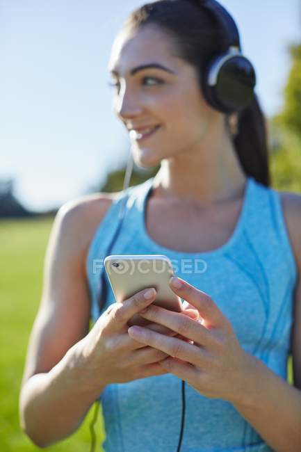 Young woman listening to music on smartphone. — Stock Photo