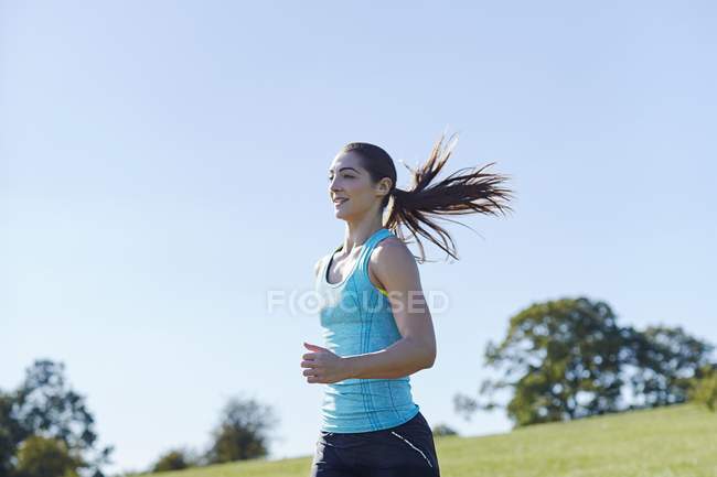 Giovane donna che corre nel parco. — Foto stock