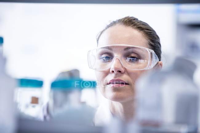 Assistante de laboratoire féminine portant des lunettes de sécurité . — Photo de stock