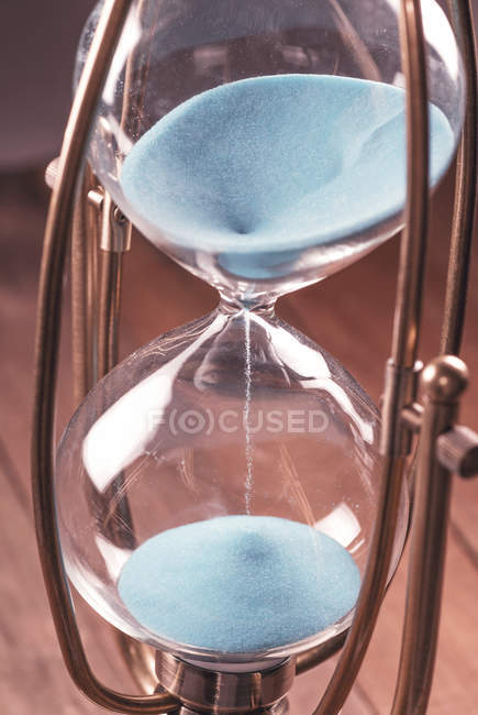 Vintage hourglass with blue sand. — Stock Photo