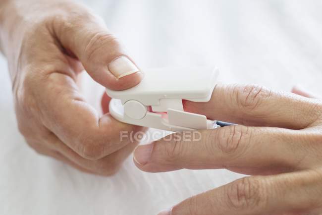 Close-up view of pulse oximeter on patient hands. — Stock Photo
