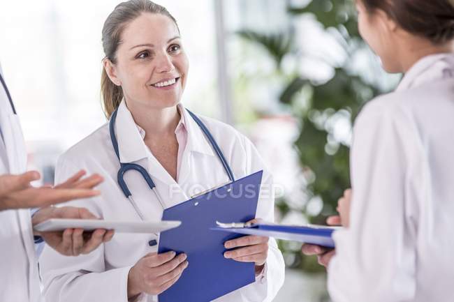 Female doctors standing with clip boards. — Stock Photo