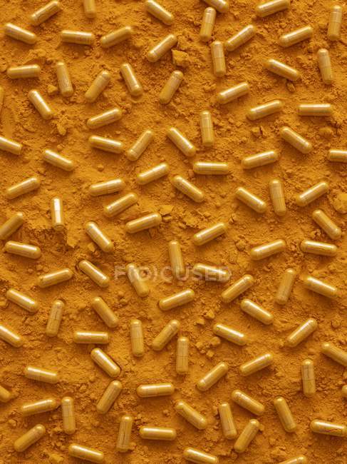 Turmeric capsules and powder, full frame. — Stock Photo