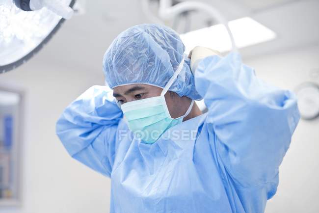 Cirurgião masculino colocando máscara cirúrgica . — Fotografia de Stock