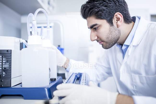 Assistente di laboratorio maschile utilizzando attrezzature . — Foto stock