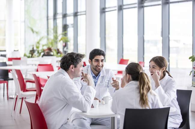 Team of doctors talking in hospital canteen. — Stock Photo