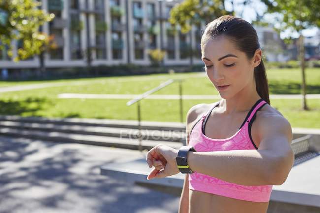 Жінка перевіряє час на спортивному смарт-годиннику . — стокове фото