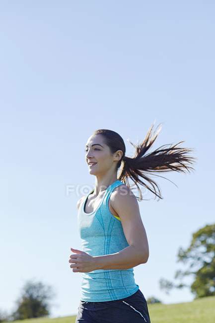 Молода жінка біжить в парку . — стокове фото